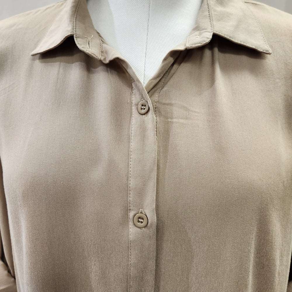 Detailed view of collar neckline of beige dress shirt
