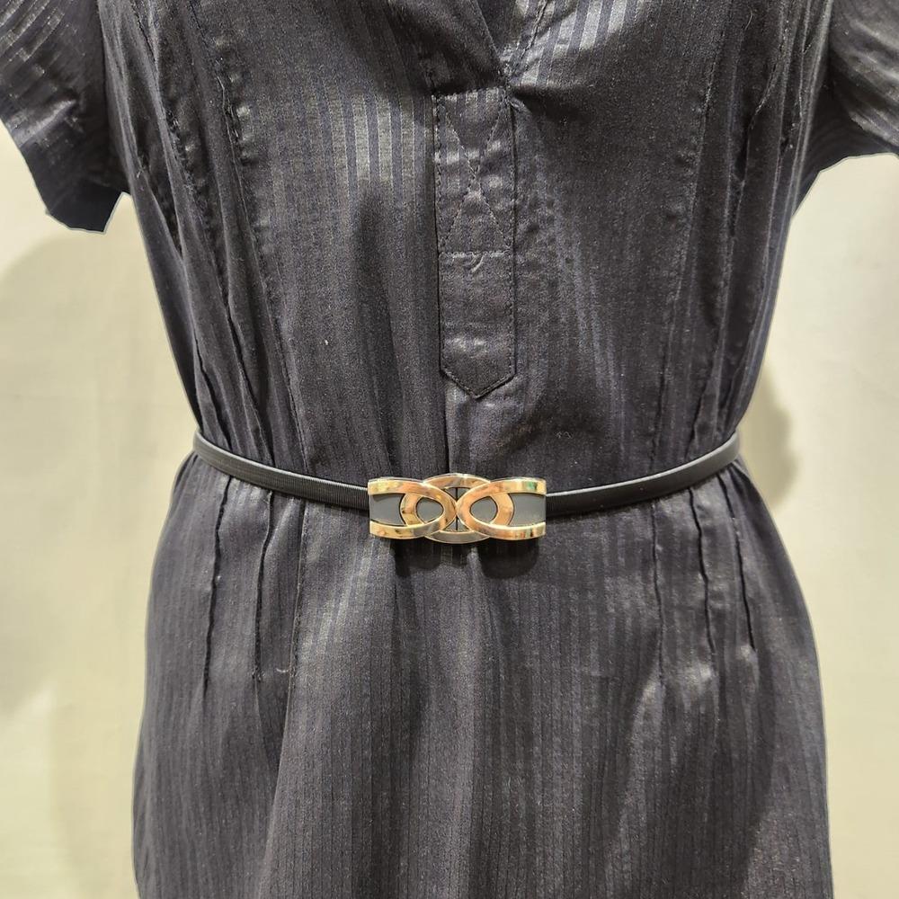 Detailed view of Black stretchy belt with stylish gold buckle
