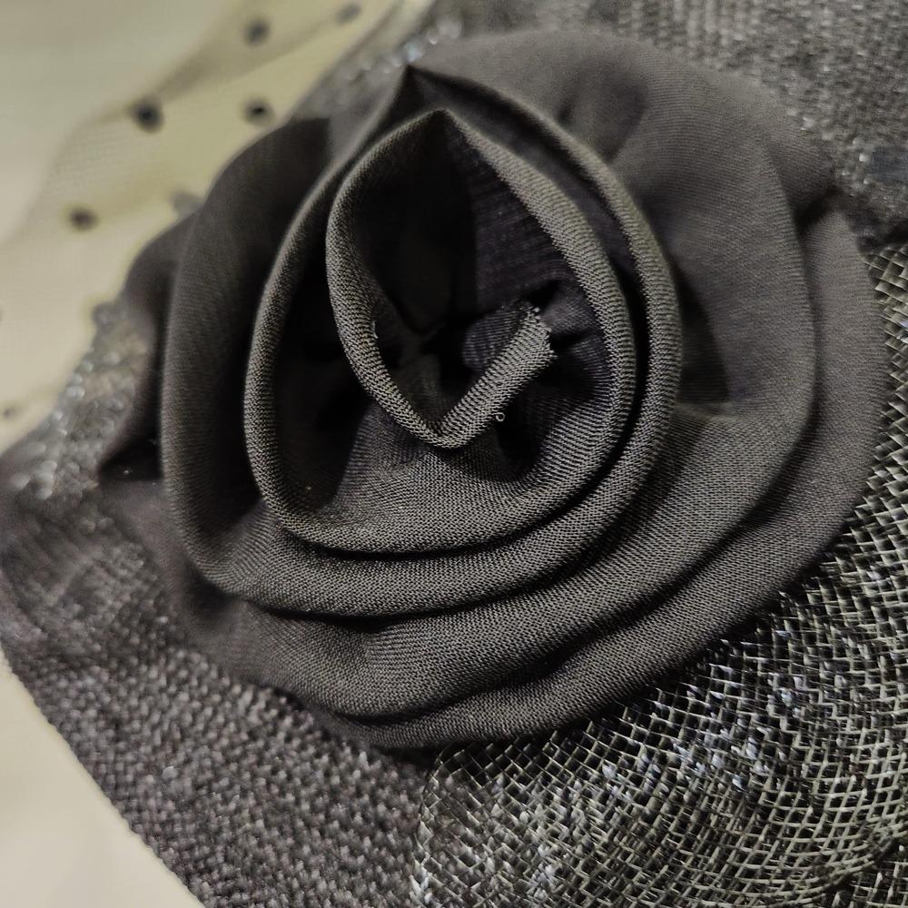 Detailed view of embellishment on black cloche hat