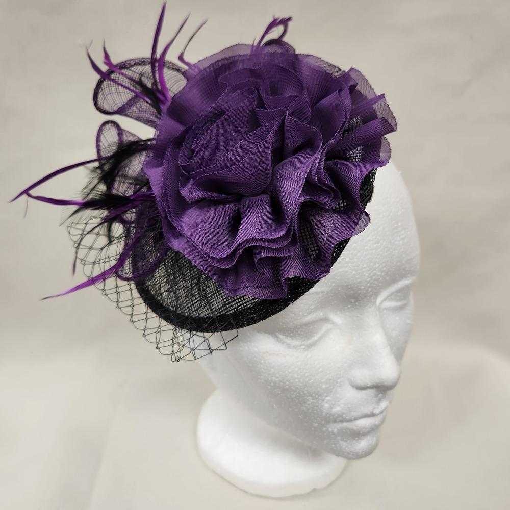 Black and purple fascinator displayed on a mannequin head