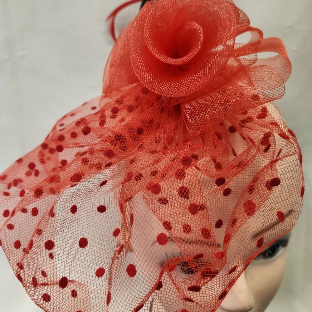 Top view of Red fascinator with mesh and feather detail