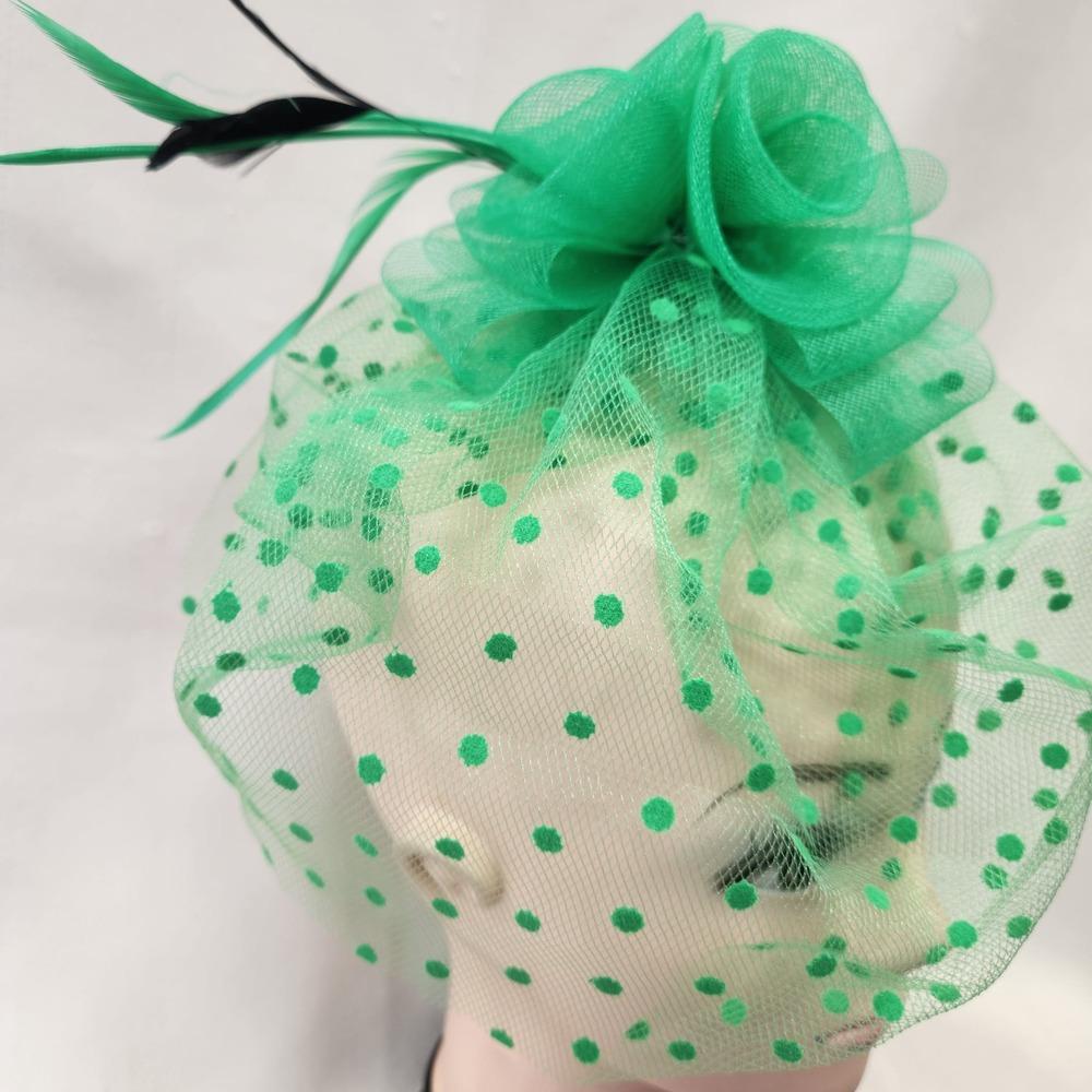 Side view of Green fascinator with mesh and feather detail
