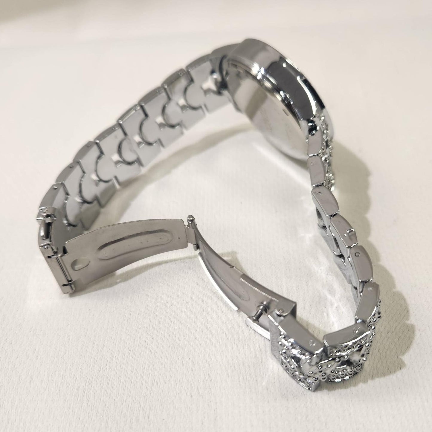 Another view of chain strap and folding clasp of silver wristwatch