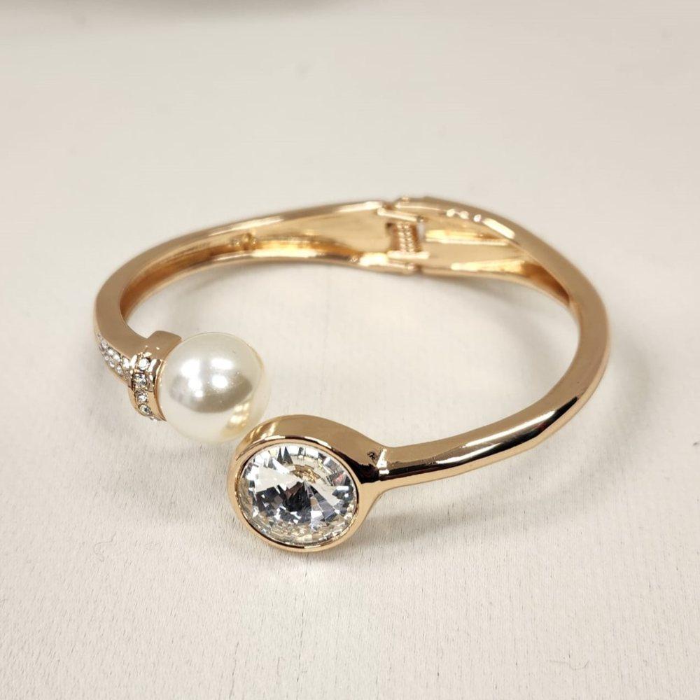 Detailed view of Gold bracelet with clear stones and pearl