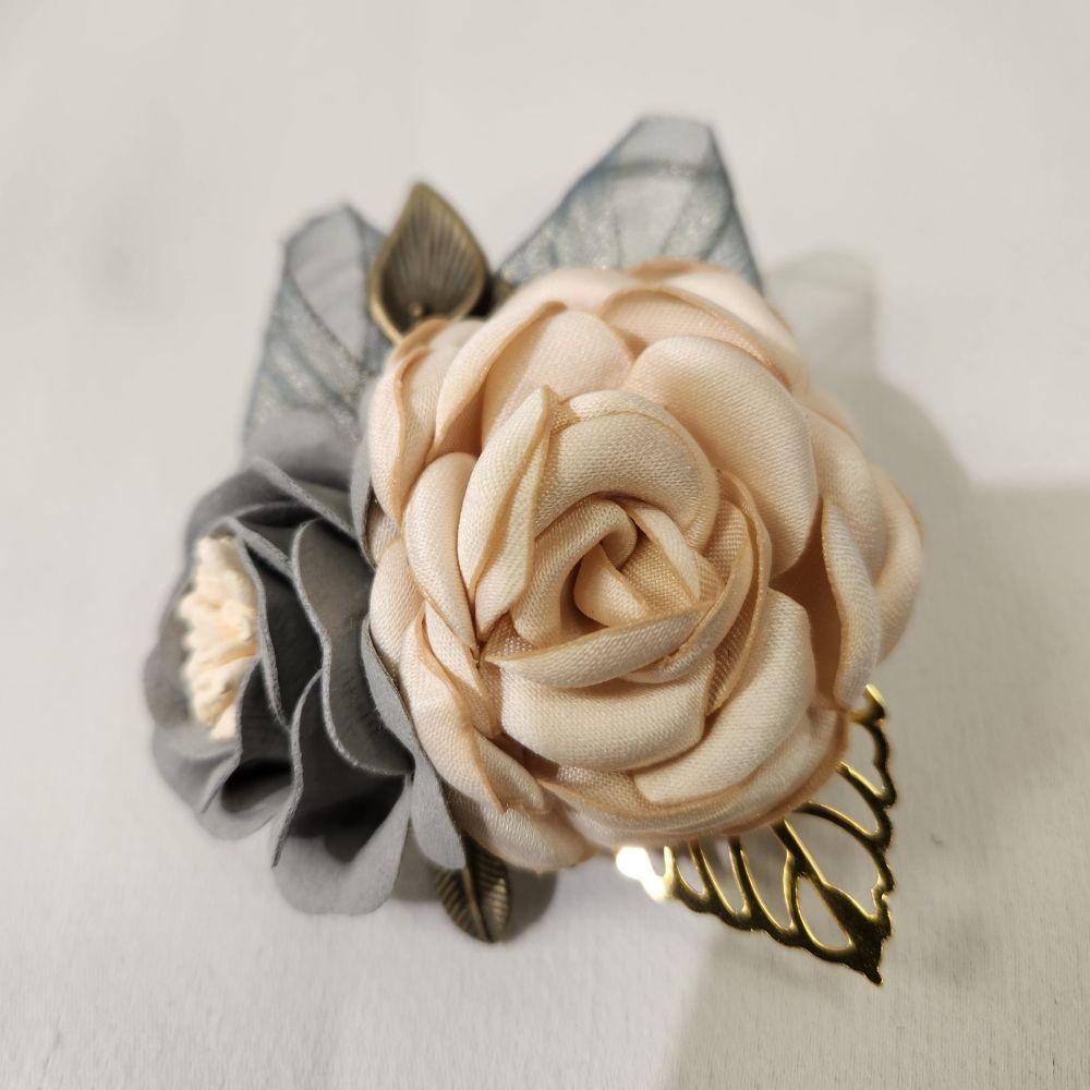 Another view of brooch and hair clip in shades of cream and grey