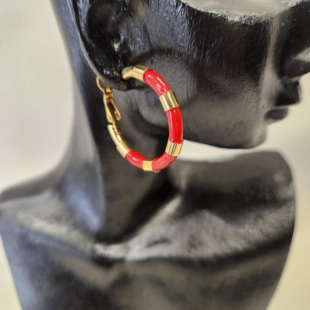 Detailed view of Gold hoops with red enamel stripes