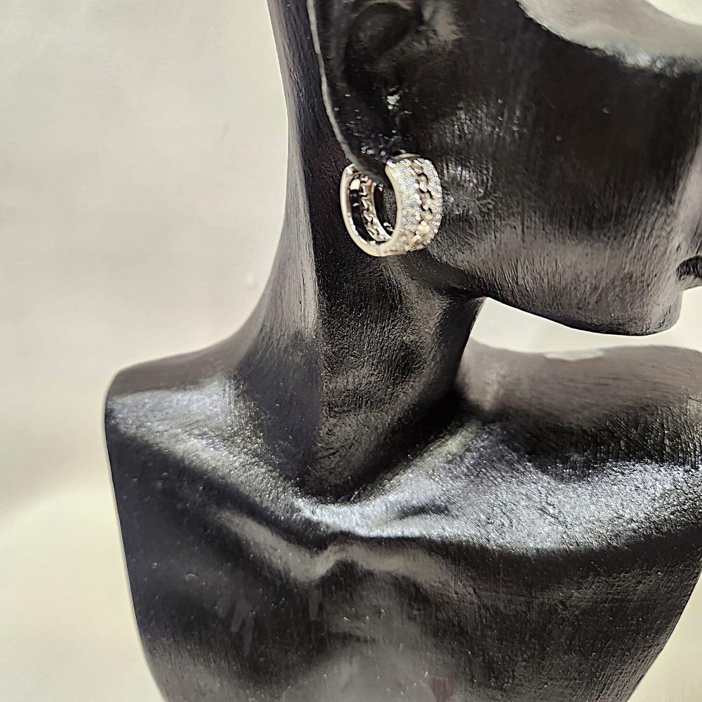 Side view of Small hoop silver hued earrings