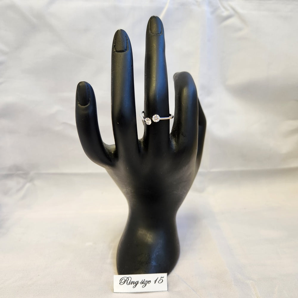 Delicate silver frame ring with clear stones displayed on a mannequin stand