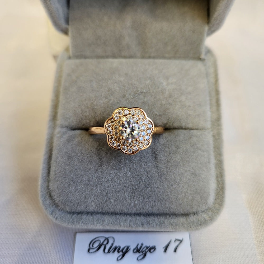 Detailed view of halo set gold color ring in floral design
