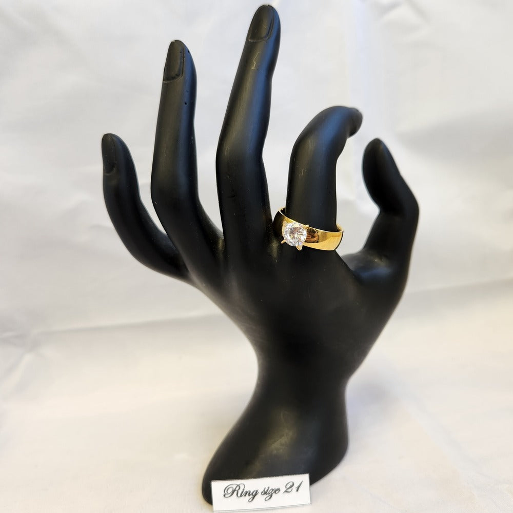Ring in gold color with prong set stone displayed on a mannequin stand