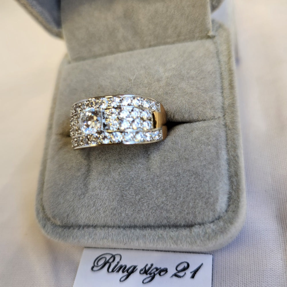 Detailed view of wide gold band ring with dazzling stone setting