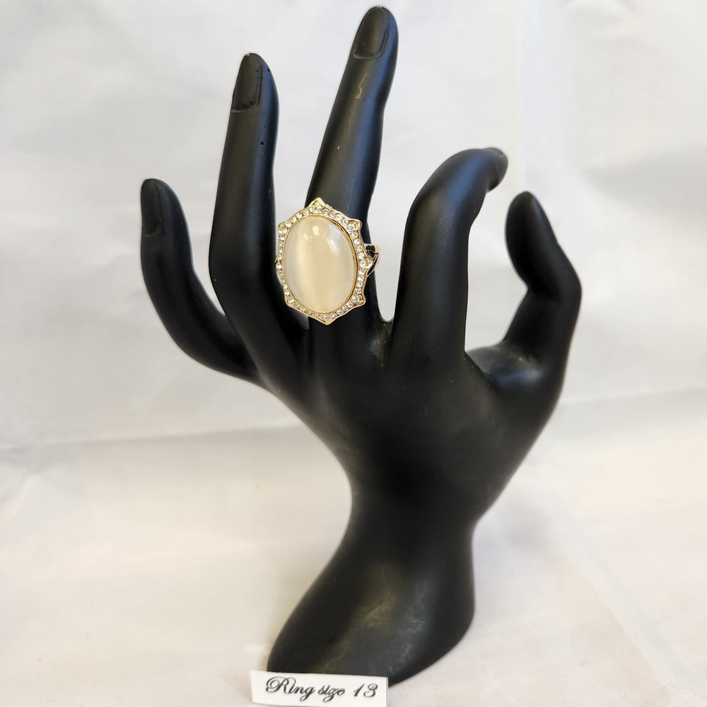 Bold ring with cobochon cut center stone displayed on a mannequin stand