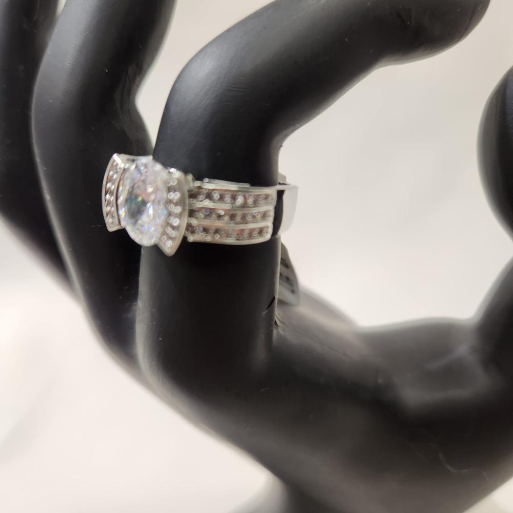 Detailed side view of Silver hued ring with round center stone