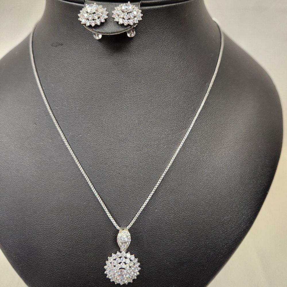 Another view of Three piece silver tone jewelry set with clear stones