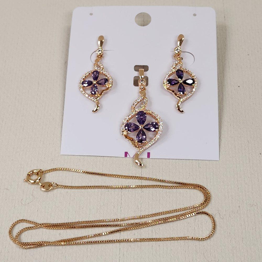 Gold hued jewelry set with clear and purple stones
