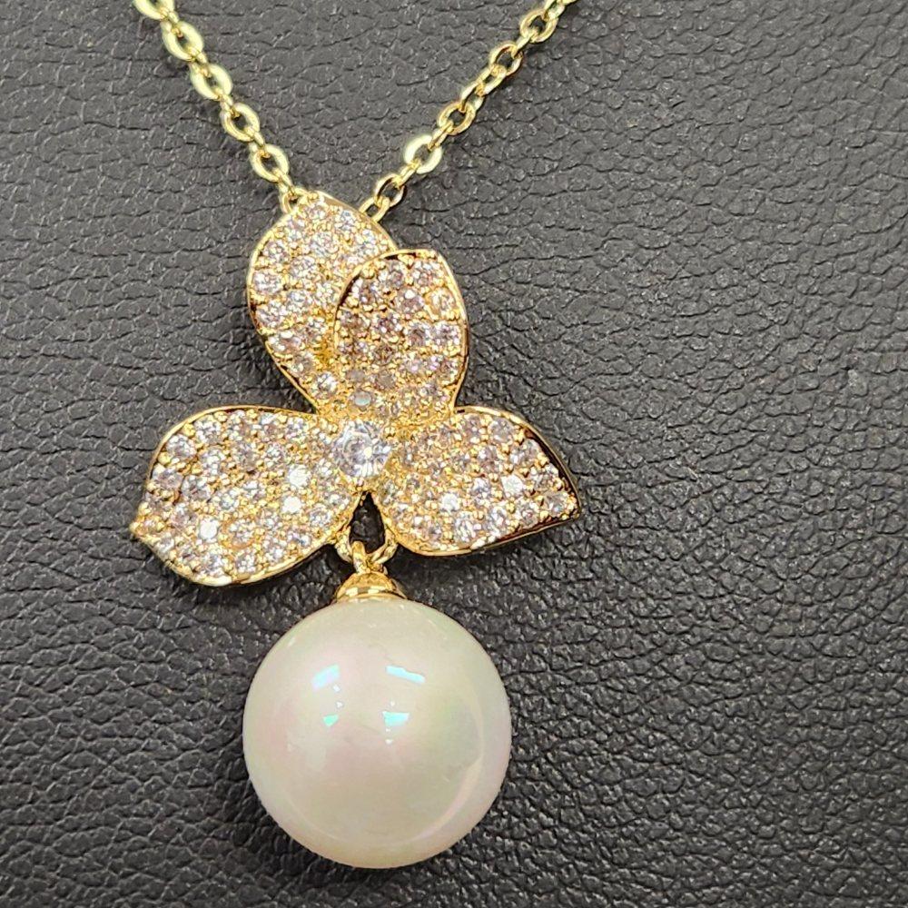 Detailed view of pendant with stones and pearl