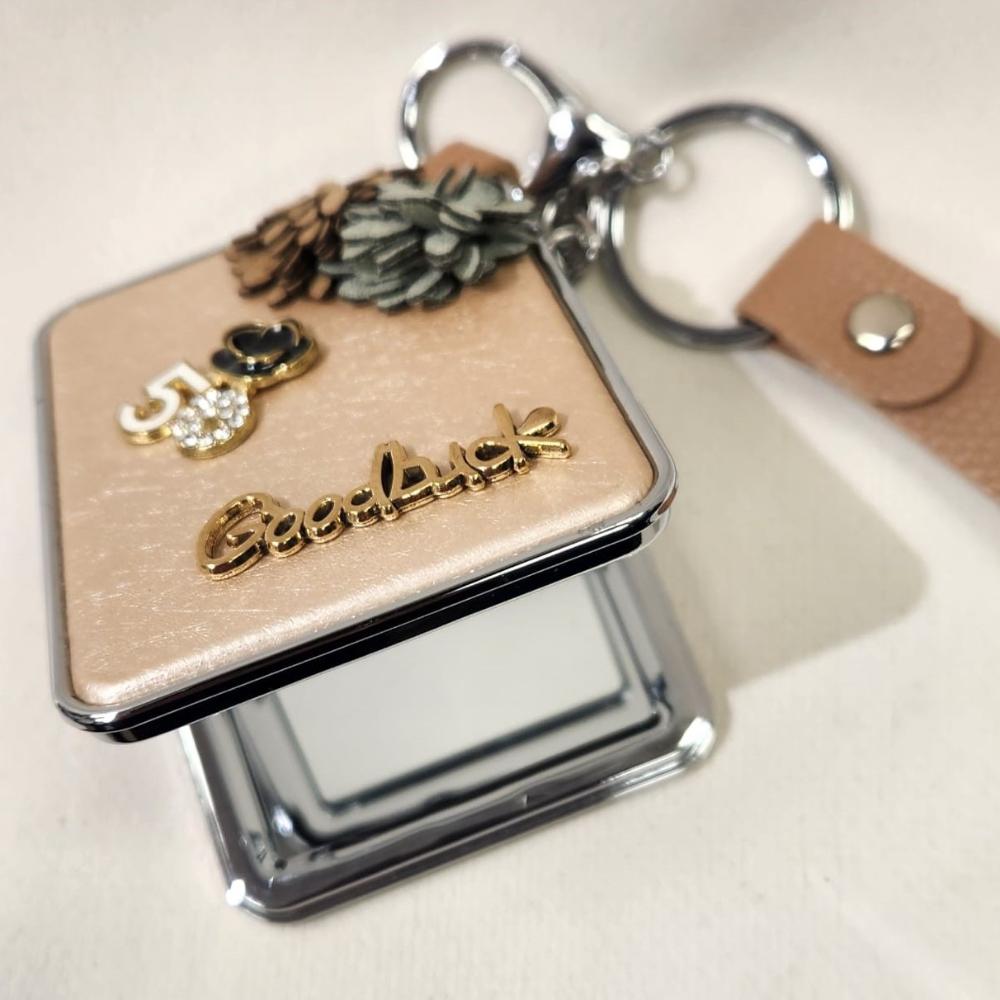 Detailed view of Mirror purse charm in pearly beige finish