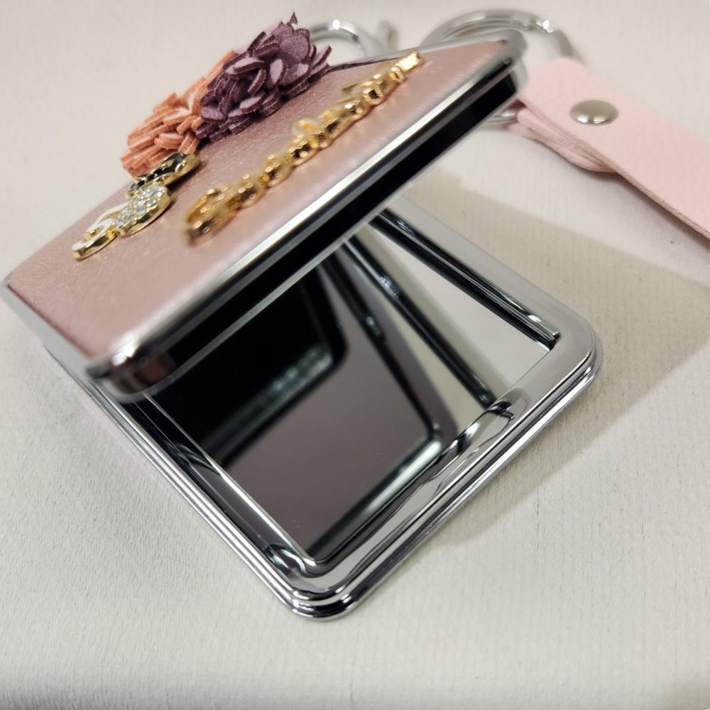 Mirror purse charm in pearly pink finish when opened partially