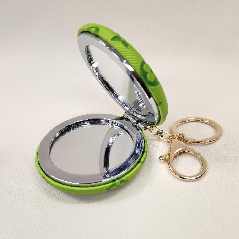 Green Pocket mirror with engraved floral pattern and a keyring when opened
