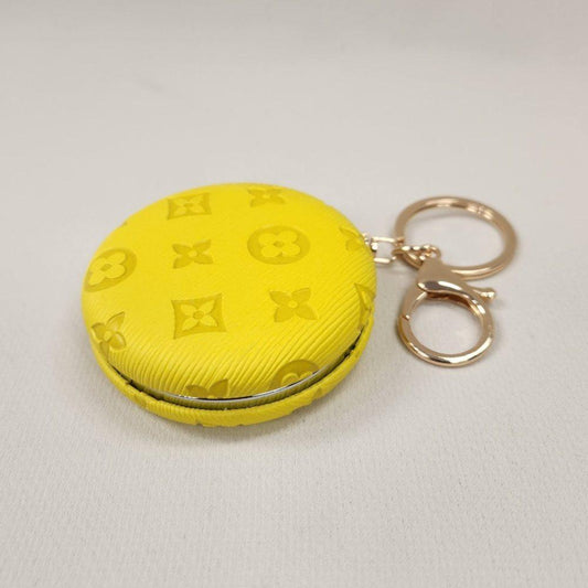 Yellow Pocket mirror with engraved floral pattern and a keyring when closed