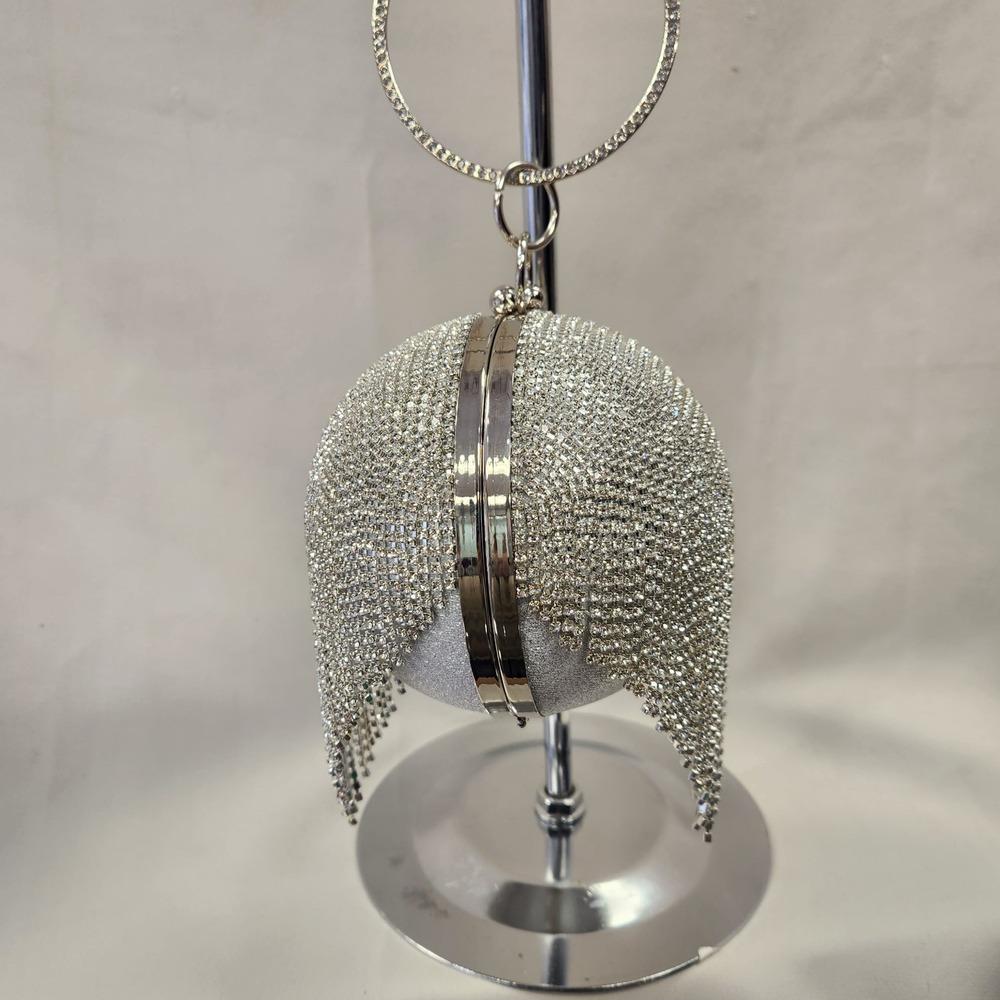 Side view of Silver globe shaped party purse with clear stone tassels