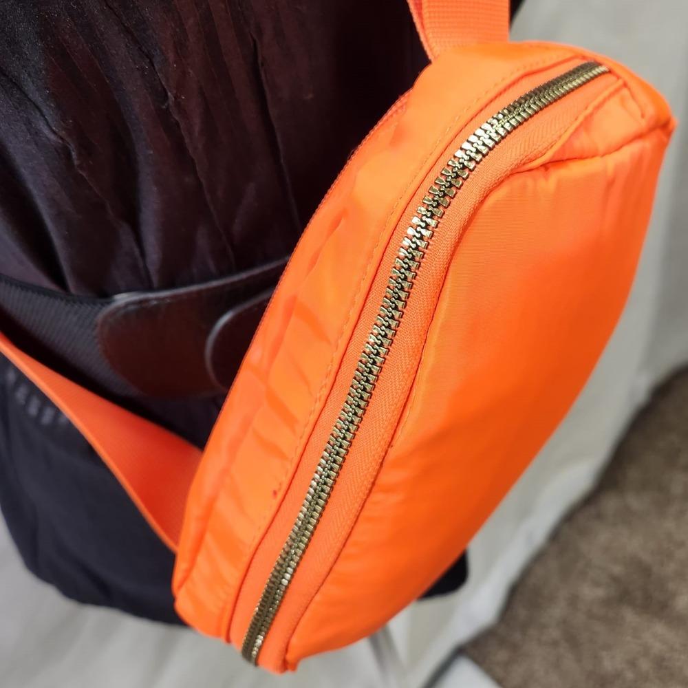 Gold hardware of orange microfiber side bag