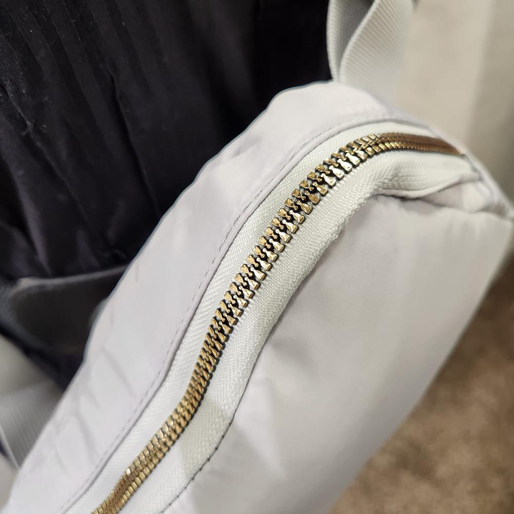 Gold hardware of light grey microfiber side bag