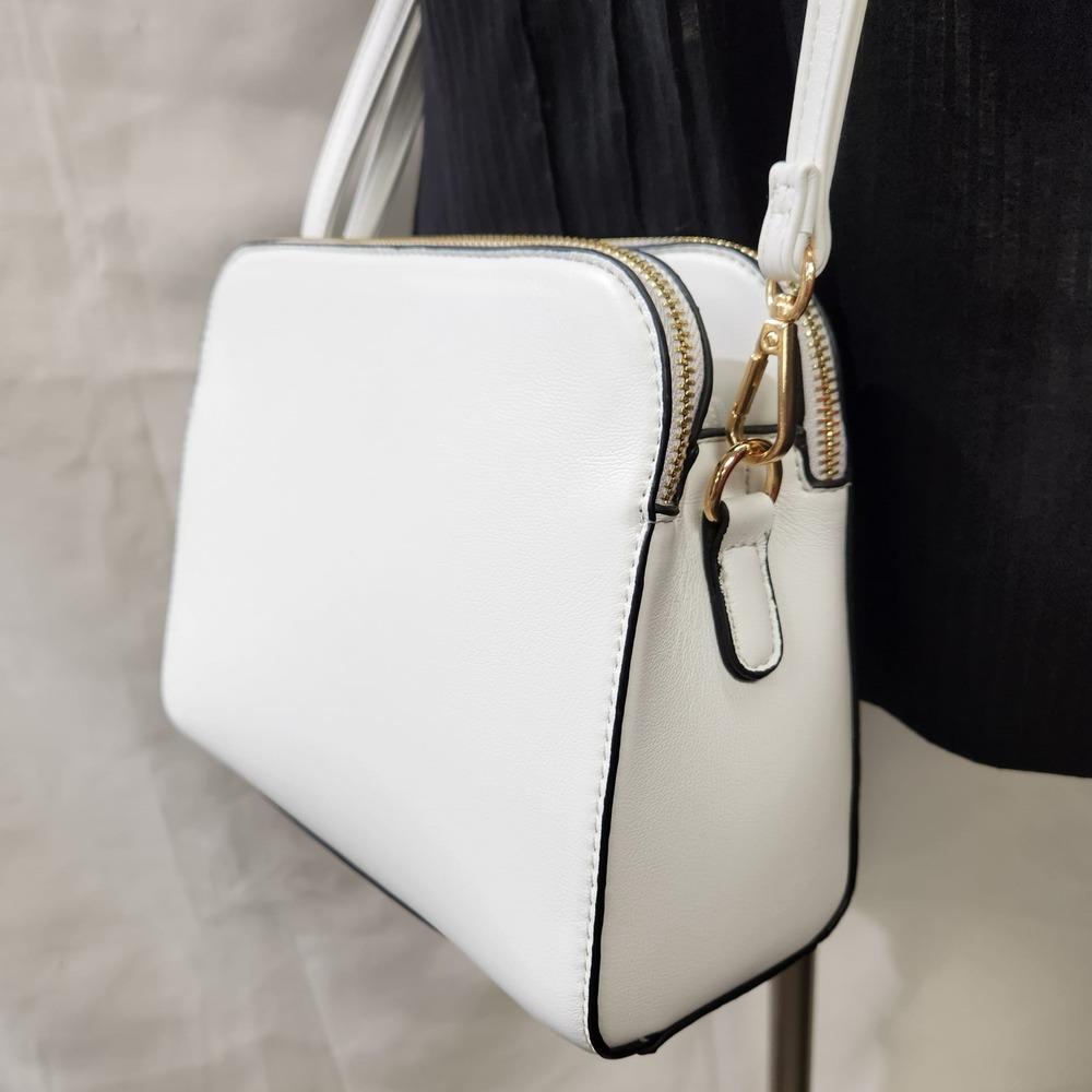 Detailed view of White side bag with triple main compartments