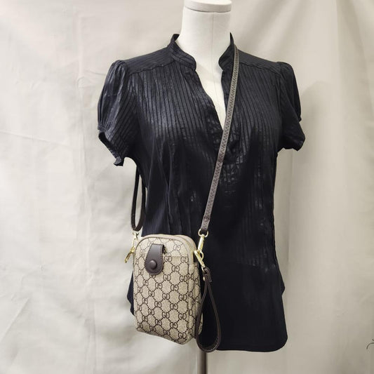 Full view of Signature print side bag in beige with brown print and strap