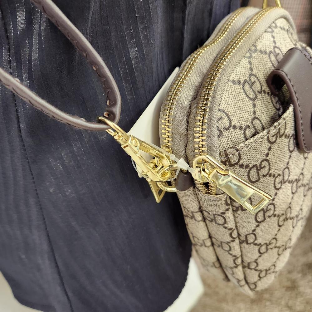 Side view of Signature print side bag in beige with brown print and strap