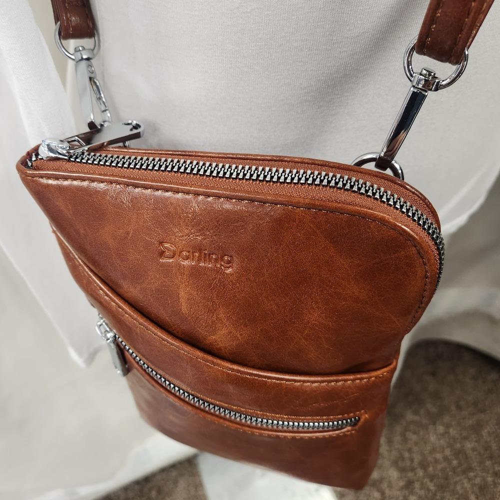 Zip closure of main compartment of small brown side bag