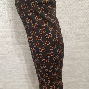 Detailed view of GD signature print on black leggings