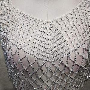 Detailed view of dressy white capelet with shimmery beads