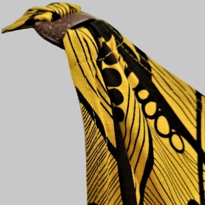 Shoulder detail of yellow with black print, sleeveless summer top