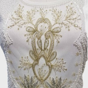 Detailed view of sequin work on white sleeveless top