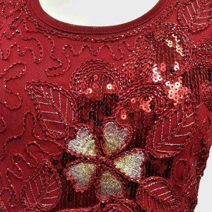 Detailed view of sequin work on red fancy top