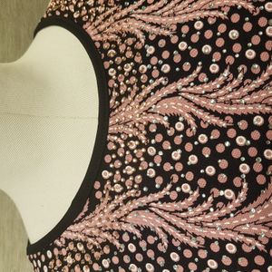 Neckline of black and pink casual top in vibrant print