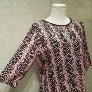 Side view of black and pink casual top in vibrant print