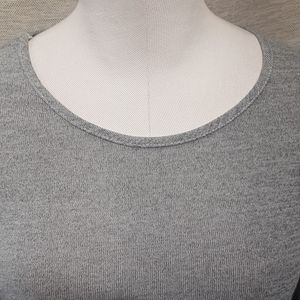 Neckline of light grey top with fold over hemline