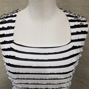 Neckline detail of white and black ruffled top