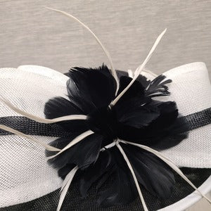 Detailed view of feather embellishment on formal black and white dress hat