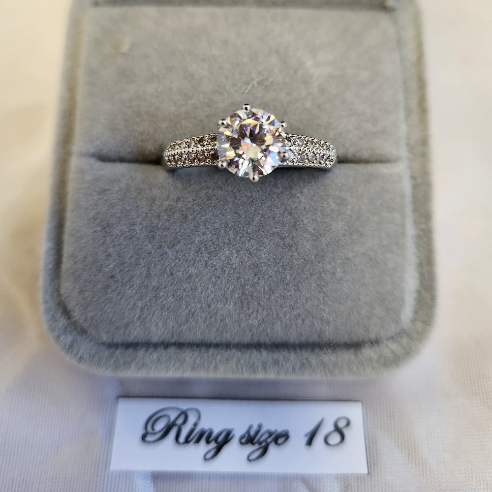Detailed view of solitare style ring with stone studded band