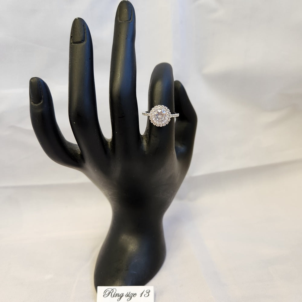 Halo shaped ring with studded band displayed on a mannequin stand
