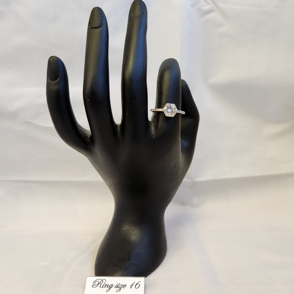 Delicate bezel set silver frame ring displayed on a mannequin stand