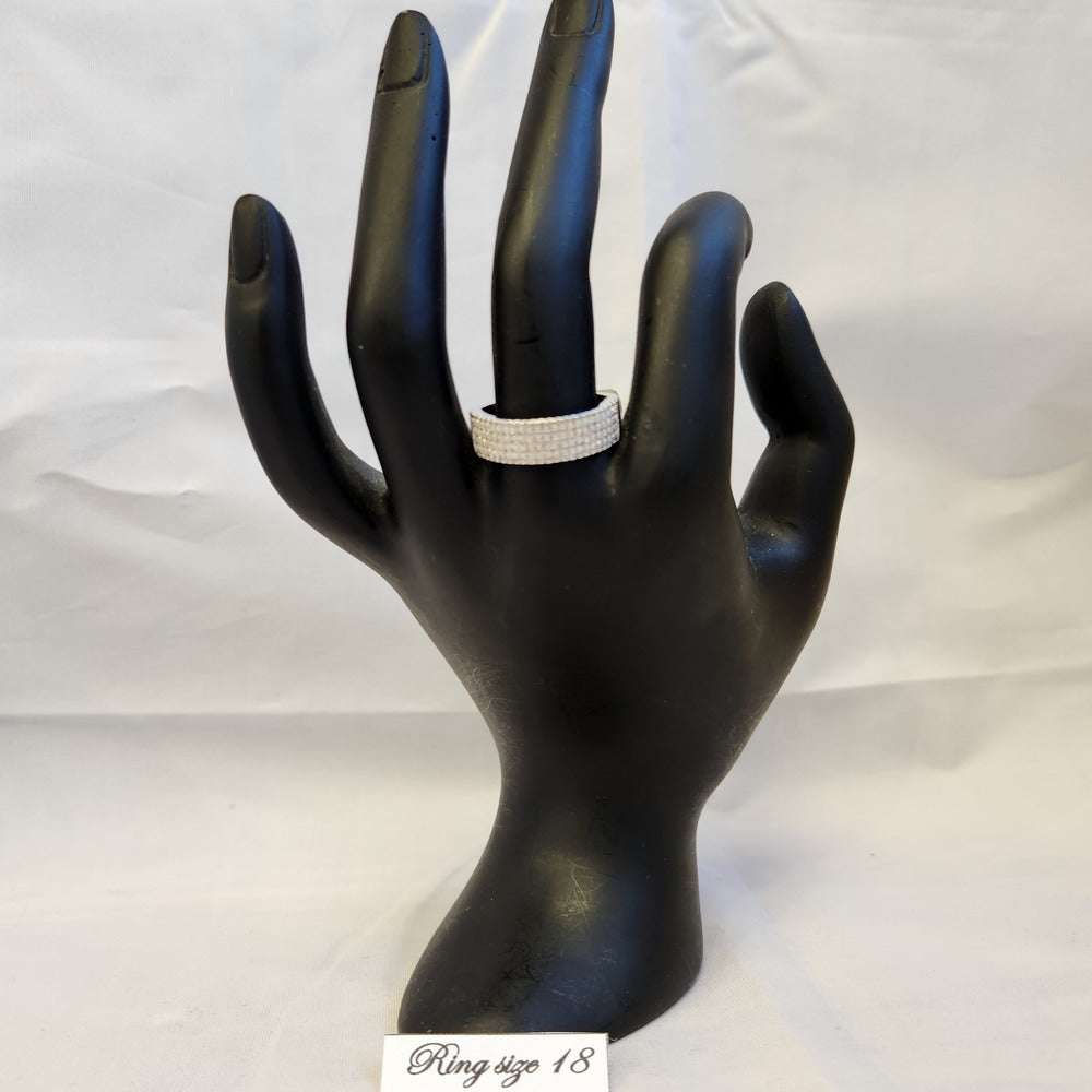 Five row stone set silver colored ring displayed on a mannequin stand