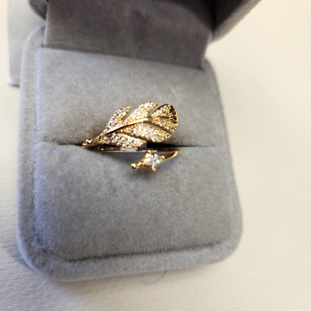 Detailed view of Nature inspired adjustable feather shaped gold frame ring