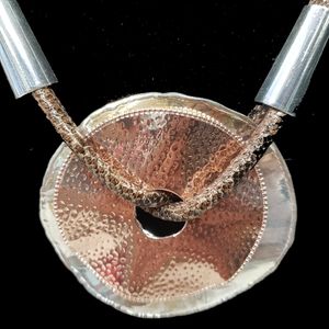 Detailed view of stacked disc necklace with leather strand
