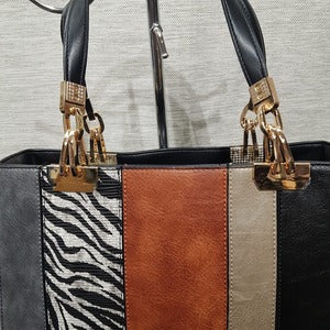 Detailed view of hardware on paneled handbag with black wallet