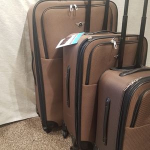 Side view of brown three piece expandable four wheeler luggage set