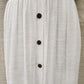 Decorative button detail on white summer skirt